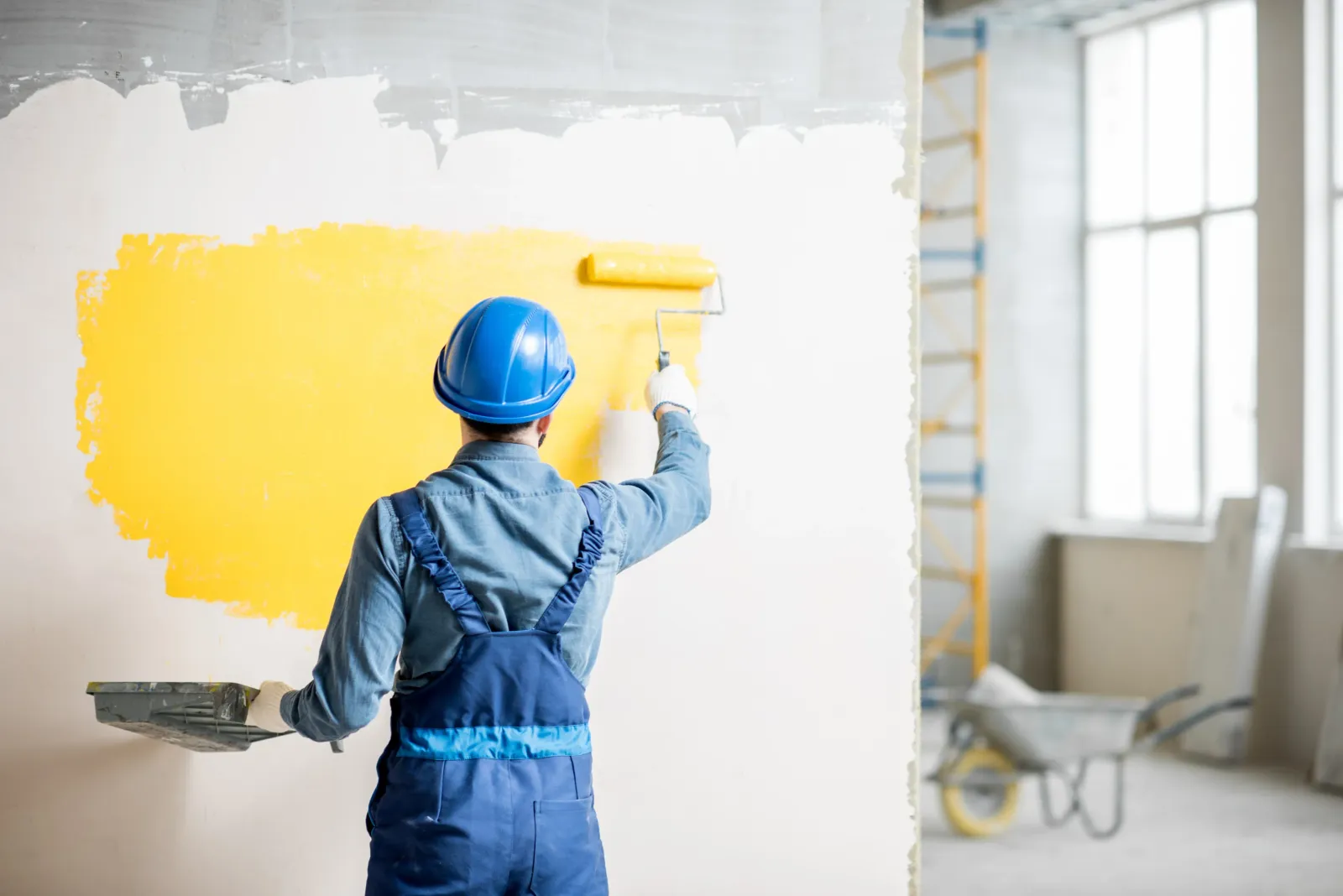 A contractor painting a wall.