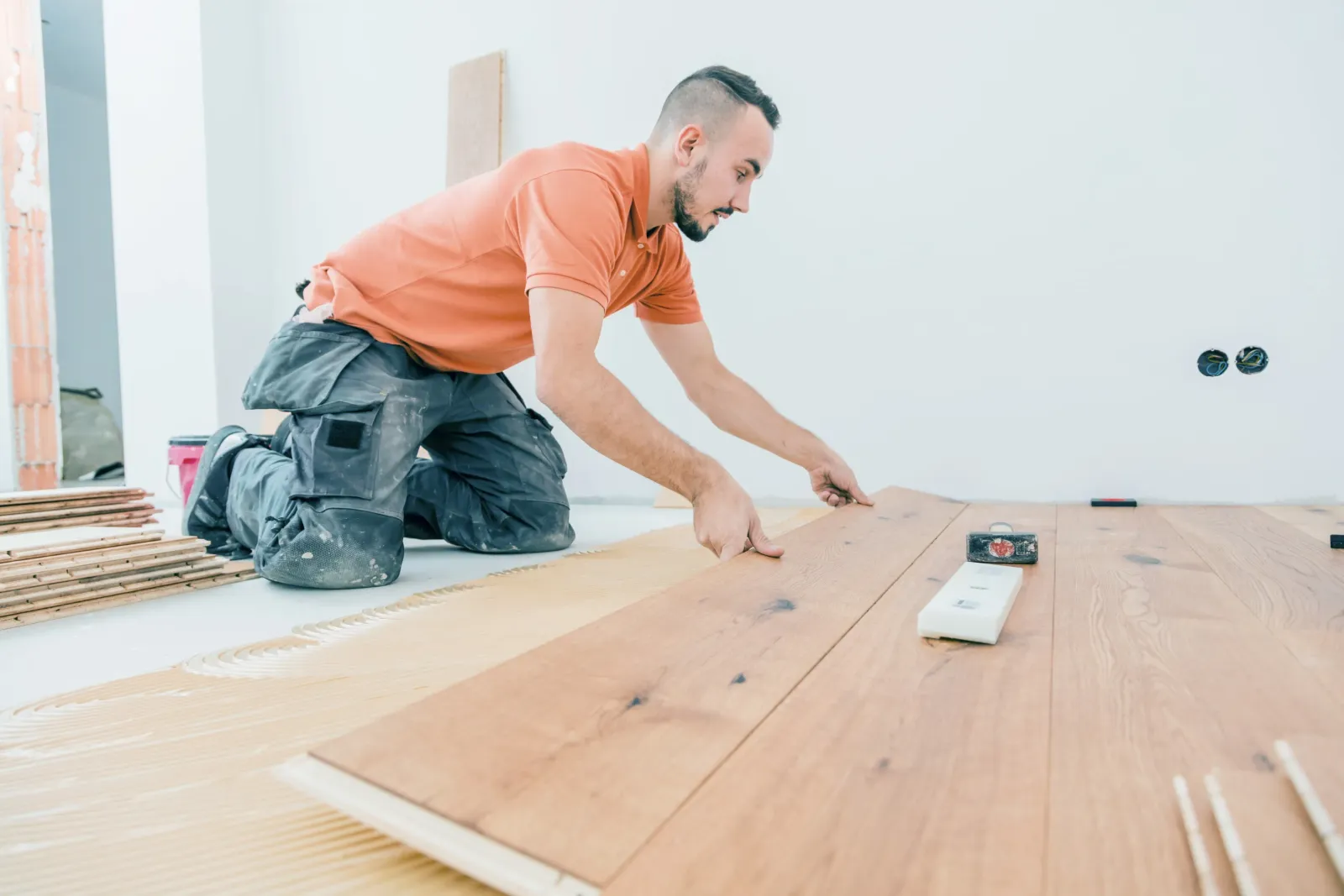 A contractor installing a hardwood floor.