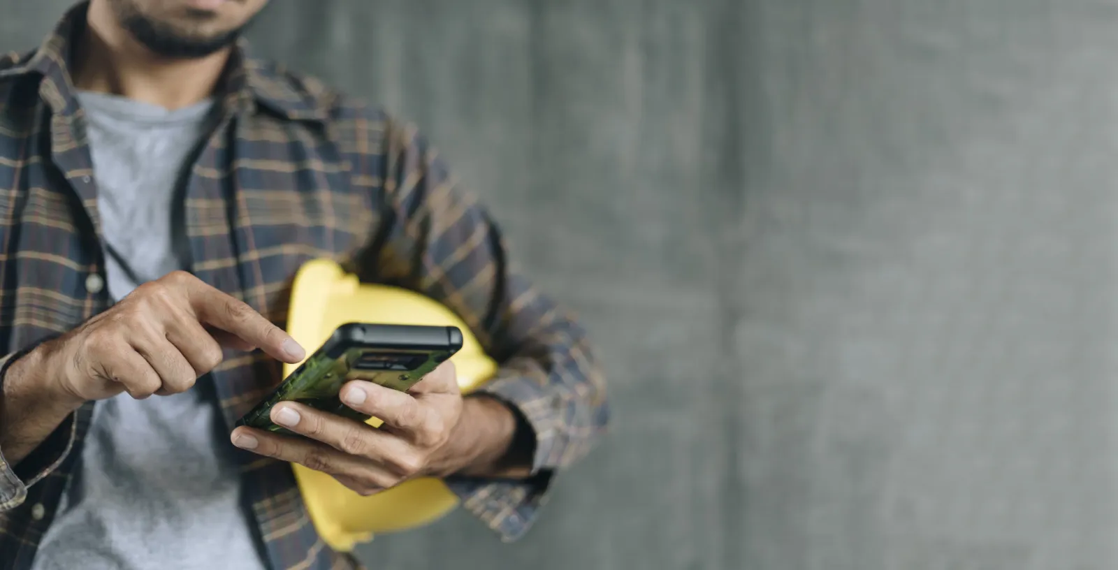 A contractor on a phone using a construction management app.