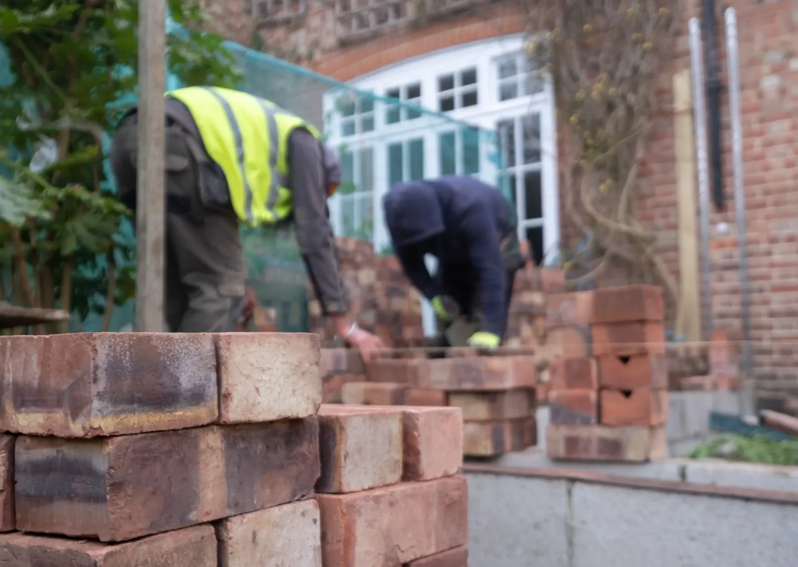 Contractors working outdoors with bricks.