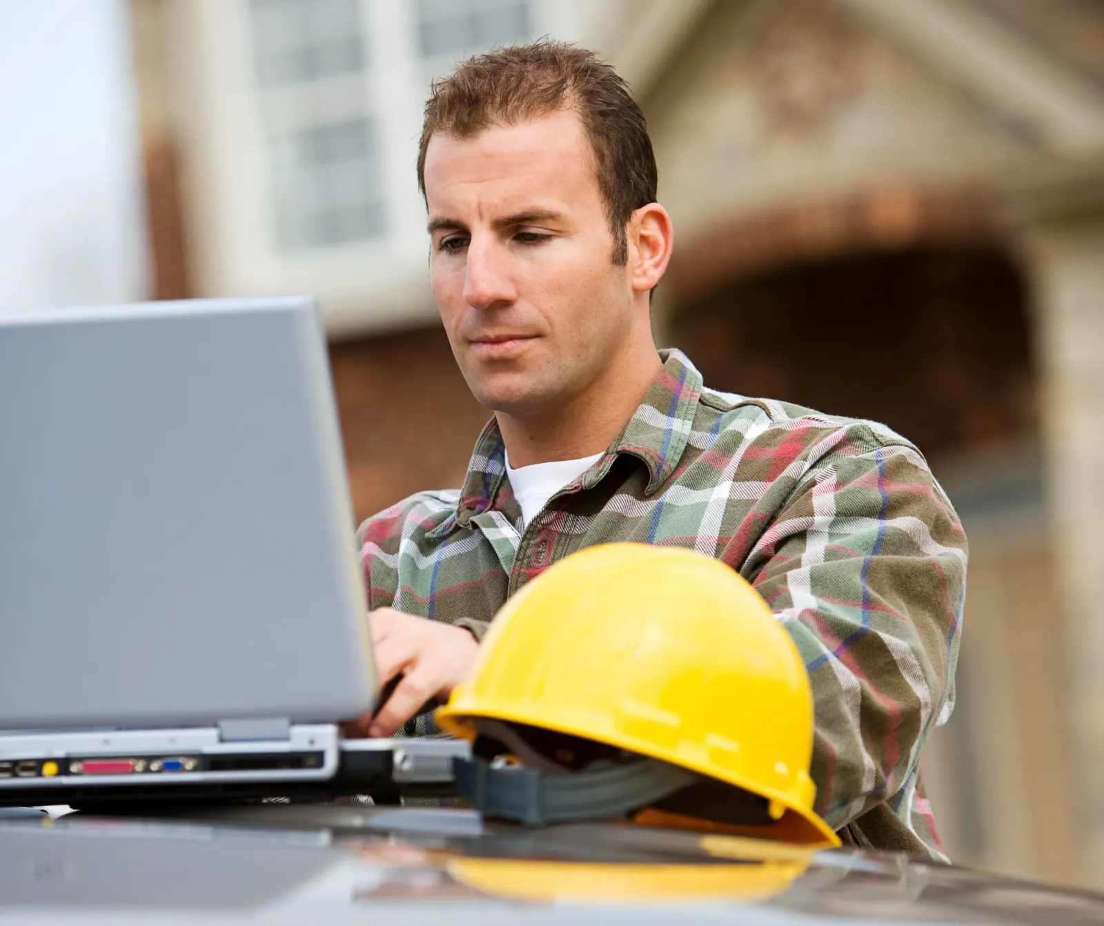 Contractor using a laptop on the job site