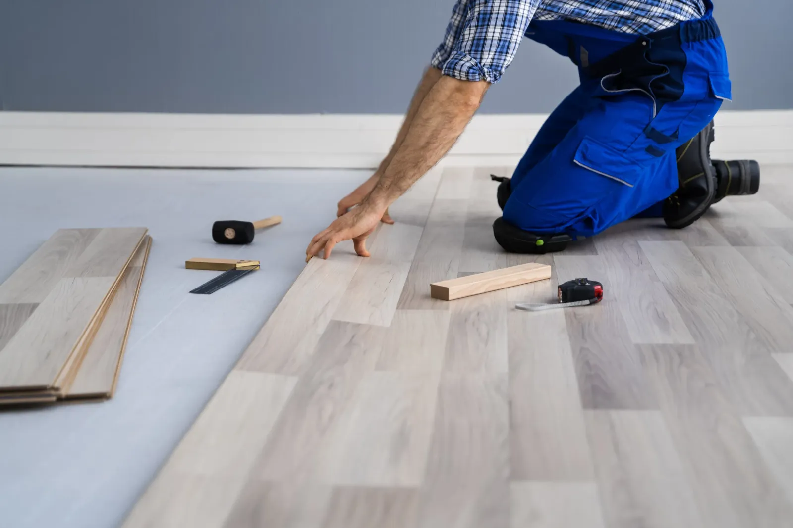 A contractor installing a hardwood floor.